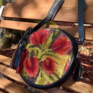 Round crossbody bag (Redondo). Woven tulip panel. Full grain black leather.